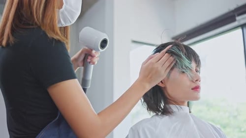 Hair Stylist Blow Drying Customer's Hair