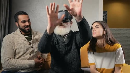 Senior Man Experiences VR with Family in Living Room