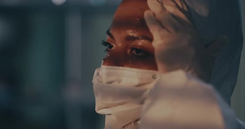 Sweaty Black Woman Taking of Hazmat Suit