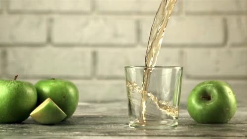 Super Slow Motion in the Glass Pours Juice From Fresh Green Apples