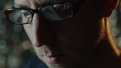 Close-up portrait of a young man working at the computer.