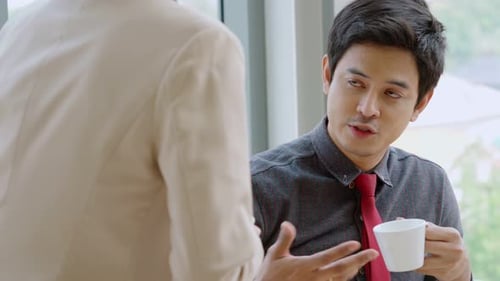 Two Business People Talk Project Strategy at Office