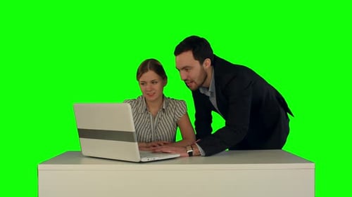 Business People Having Meeting Around Table with Laptop on a Green Screen