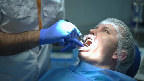 Unrecognizable Dentist Examining Oral Cavity of Patient in Dental Chair in Slow Motion