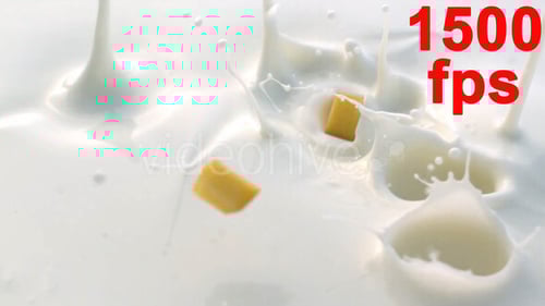 Peach Pieces Splashing Into Fresh, Creamy Milk