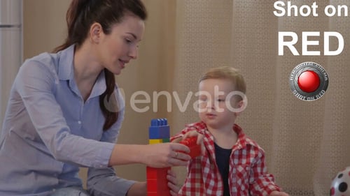 Woman and Child Playfully Building Block Tower Together