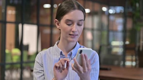 Young Adult Using Smartphone in Office Environment