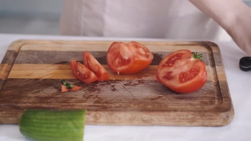 Woman Cutting Tomato on Wooden Cutting Board
