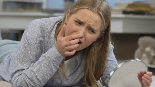Mädchen verärgert über Akne, Gesicht im Spiegel betrachten, Problemhaut, hormonelles Ungleichgewicht