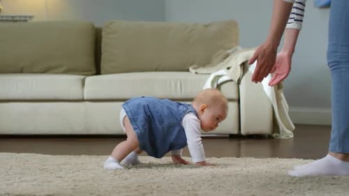 Kleines Mädchen krabbelt auf Mama zu