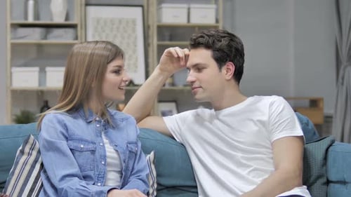 Engaged Couple Conversing on Couch