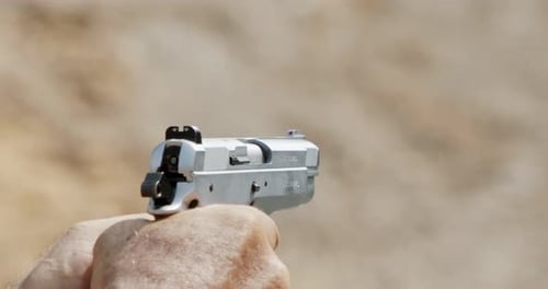 Pistole schießt Kugeln in Zeitlupe. Handfeuerwaffen im Schießstand