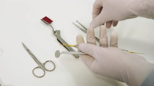 Gathering Dental Implements with Gloved Hands