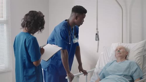 Senior Patient on Bed Talking to 2 African American Doctor in Hospital Room Health Care and