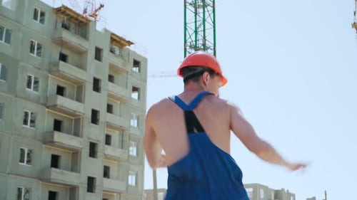 Happy Caucasian Man Builder in Hard Hat Dancing. Worker Funny Moves Background Construction Site.