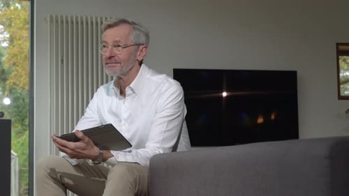 Man Using Tablet at Home on Couch