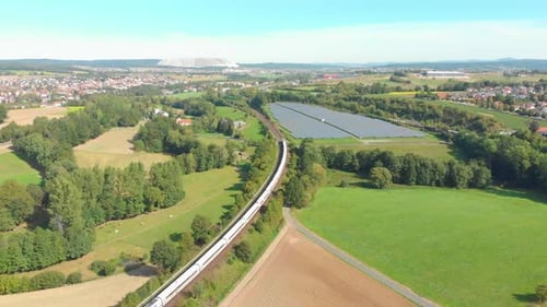 commuter train passes through landscape and farmland