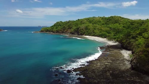 Tropical hidden white sand and blue turquoise water beach in Costa Rica. Aerial view in 4K