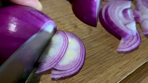Cutting Fresh Red Onion on Wooden Cutting Board