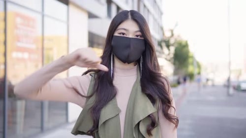 Young Asian Woman Face Mask Shows Thumb Down To Camera Shakes Her Head Street