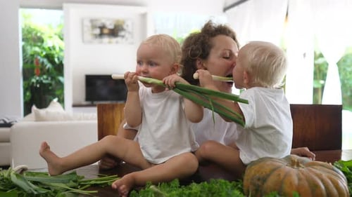 Mother with Children Holding Green Onions Indoors