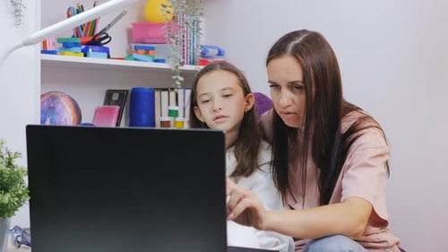 Mother and Daughter Using Laptop Together at Home