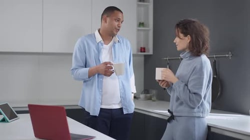 Couple Conversing Over Coffee in Modern Kitchen