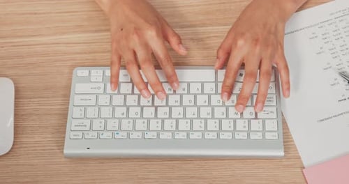 Closeup of a White Keyboard From a Computer Standing on a Wooden Desk on It a Working Woman Young