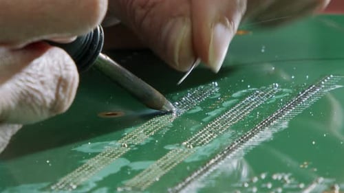 Manual soldering of electronic components on a PCB board, close up