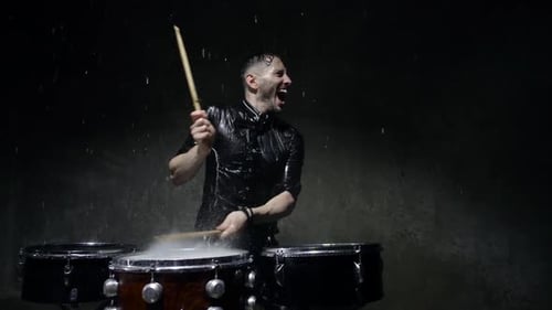 Energetic Drummer Playing in the Rain at Night