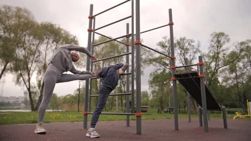 Mother and Daughter Doing Exercises on Open Air Sport Playground