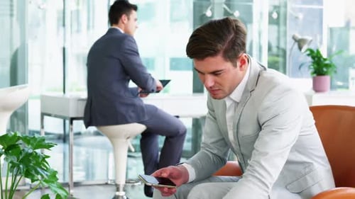 Worried Man on Phone in a Busy Office