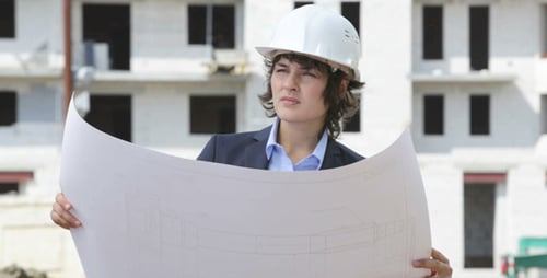 Female Architect Studying Blueprints on Construction Site