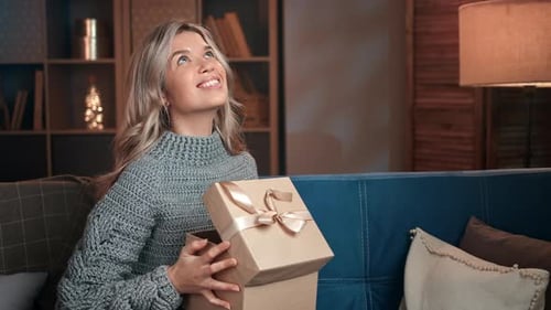 Woman Smiling As She Opens Gift Box