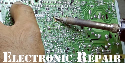 Hands Soldering Circuit Board at Workplace