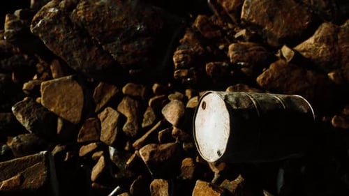 Rusty Destroyed Metal Barrel on Beach Rocks