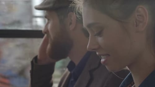 Couple Using Technology on Train or Bus