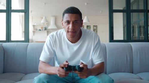 Man Losing at Video Game on Couch Indoors