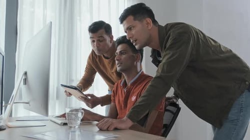 Indische Programmierer diskutieren Projekt am Computer im Büro