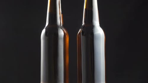 Brown Beer Bottles Rotating on a Black Background