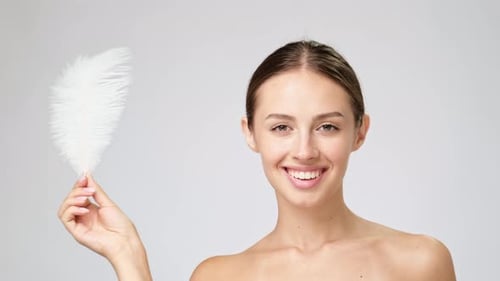 Smiling Woman Posing with White Feather