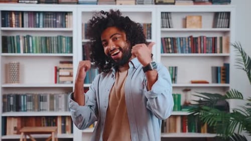 Happy Man Gives Thumbs Up by Bookshelf