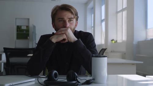 Man Contemplating at Desk in Modern Office