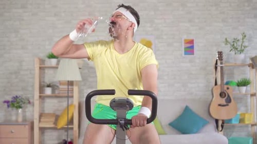 Funny Man Drinking Water on Exercise Bike