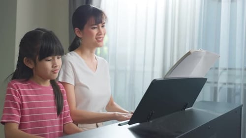 Mother and Child Playing Piano Together at Home