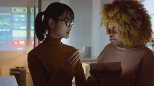 Diverse Female Colleagues Working with Tablet in Office at Night
