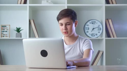 Teenage Boy Video Calling on Laptop at Home