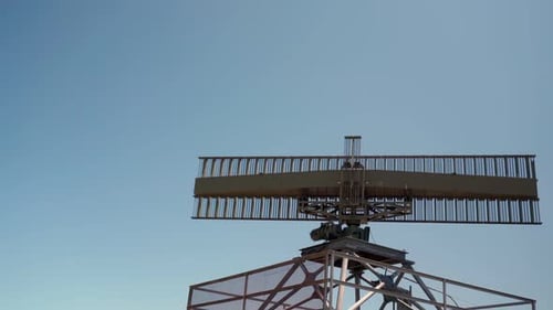 Radar Antenna Rotating Against Blue Sky