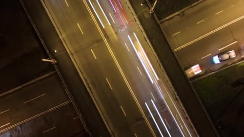 Vista aérea de la intersección de carreteras con tráfico pesado que se mueve rápidamente por la noche