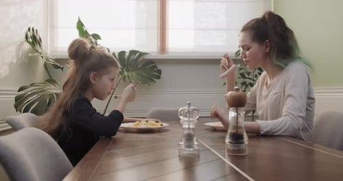 Child and Young Adult Having Meal Together